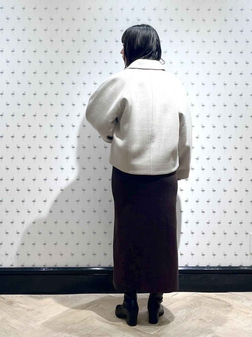 ベージュ系のブルゾン、ブラウン系のワンピース、ブラック系のブーツを着用したレディースの冬コーディネートの3枚目の写真