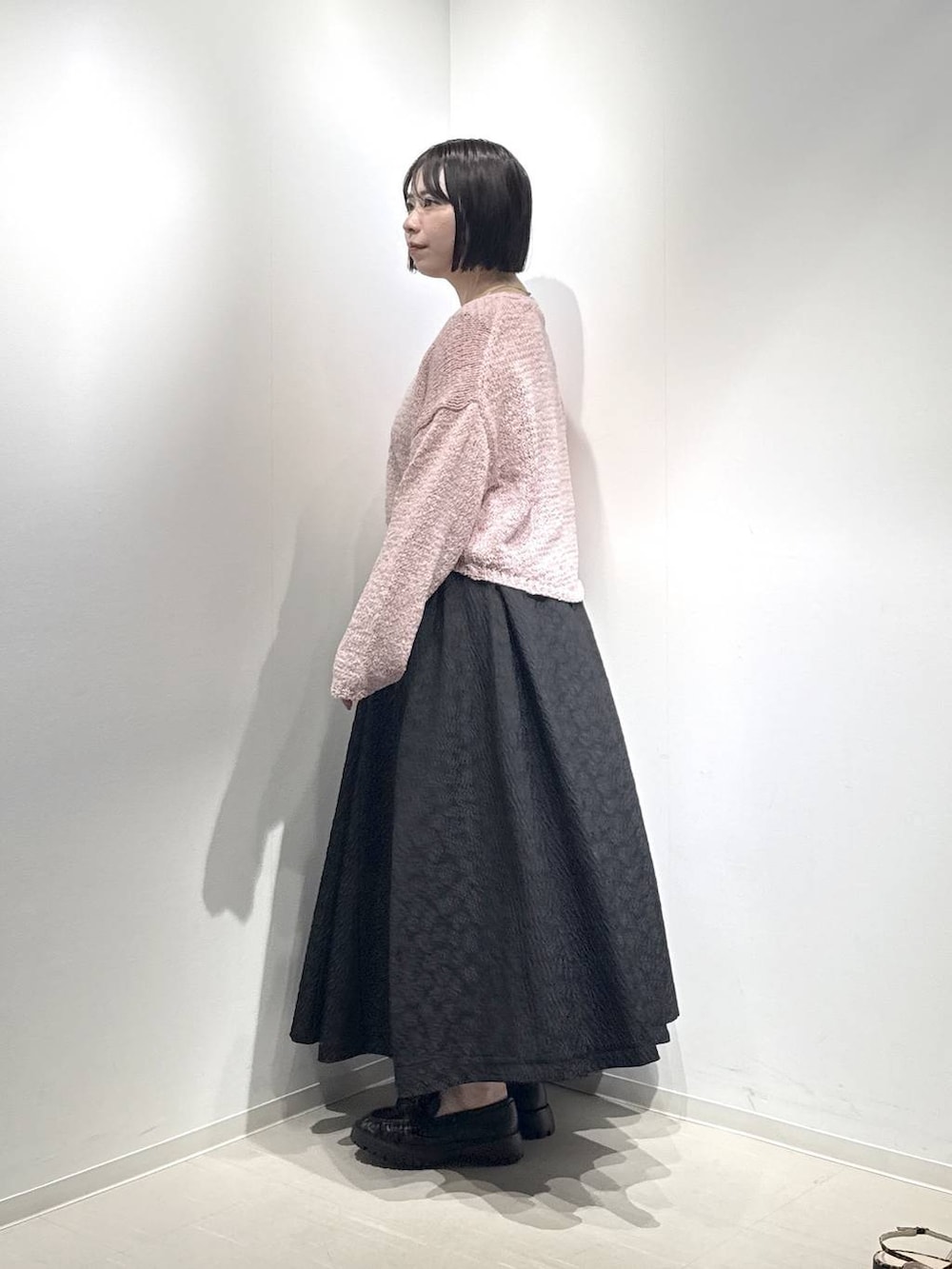 ブラック系のローファー、ピンク系のカーディガン/ボレロ、ブラック系のスカートを着用したレディースの冬コーディネートの2枚目の写真