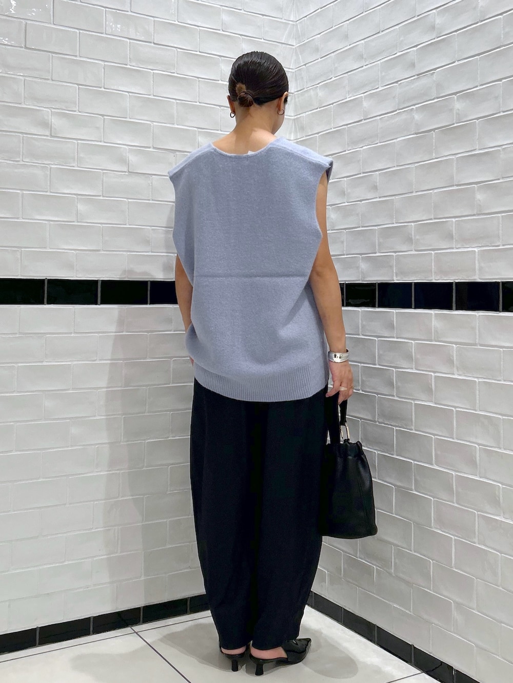 ブラック系のその他パンツ、ブルー系のベスト、ブラック系のパンプスを着用したレディースの秋コーディネートの2枚目の写真