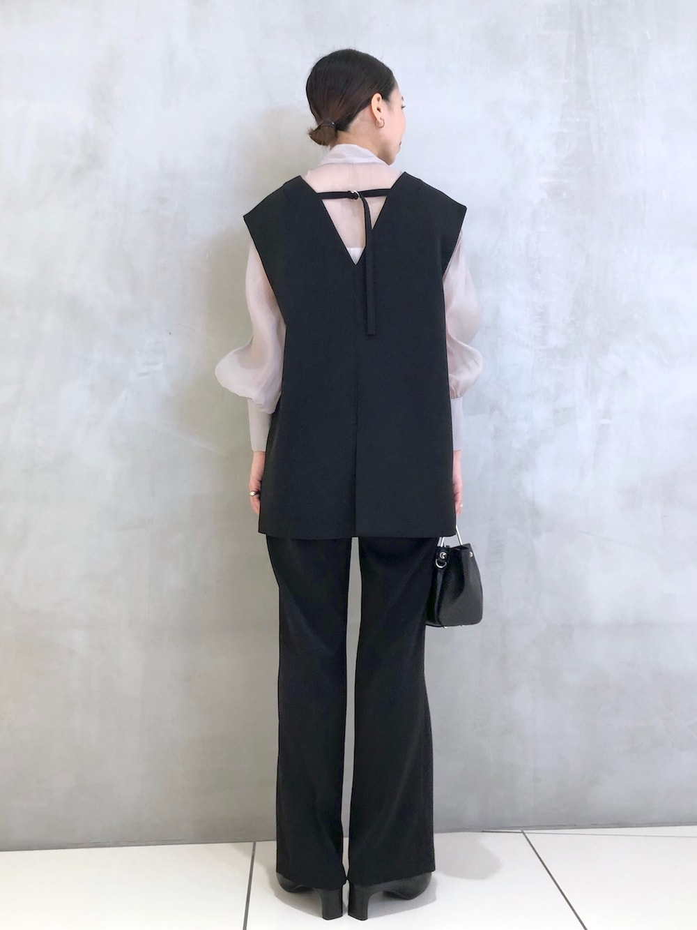 ブラック系のスーツセット、ブラック系のショルダーバッグ、ブラック系のパンプスを着用したレディースの冬コーディネートの3枚目の写真