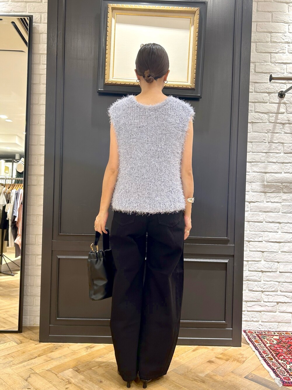 ブルー系のベスト、ブラック系のデニムパンツ、ブラック系のショルダーバッグを着用したレディースの夏コーディネートの2枚目の写真