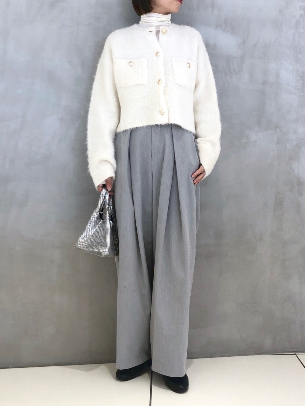 ホワイト系のカーディガン/ボレロ、ホワイト系のTシャツ/カットソー、シルバー系のショルダーバッグを着用したレディースの秋コーディネートの2枚目の写真