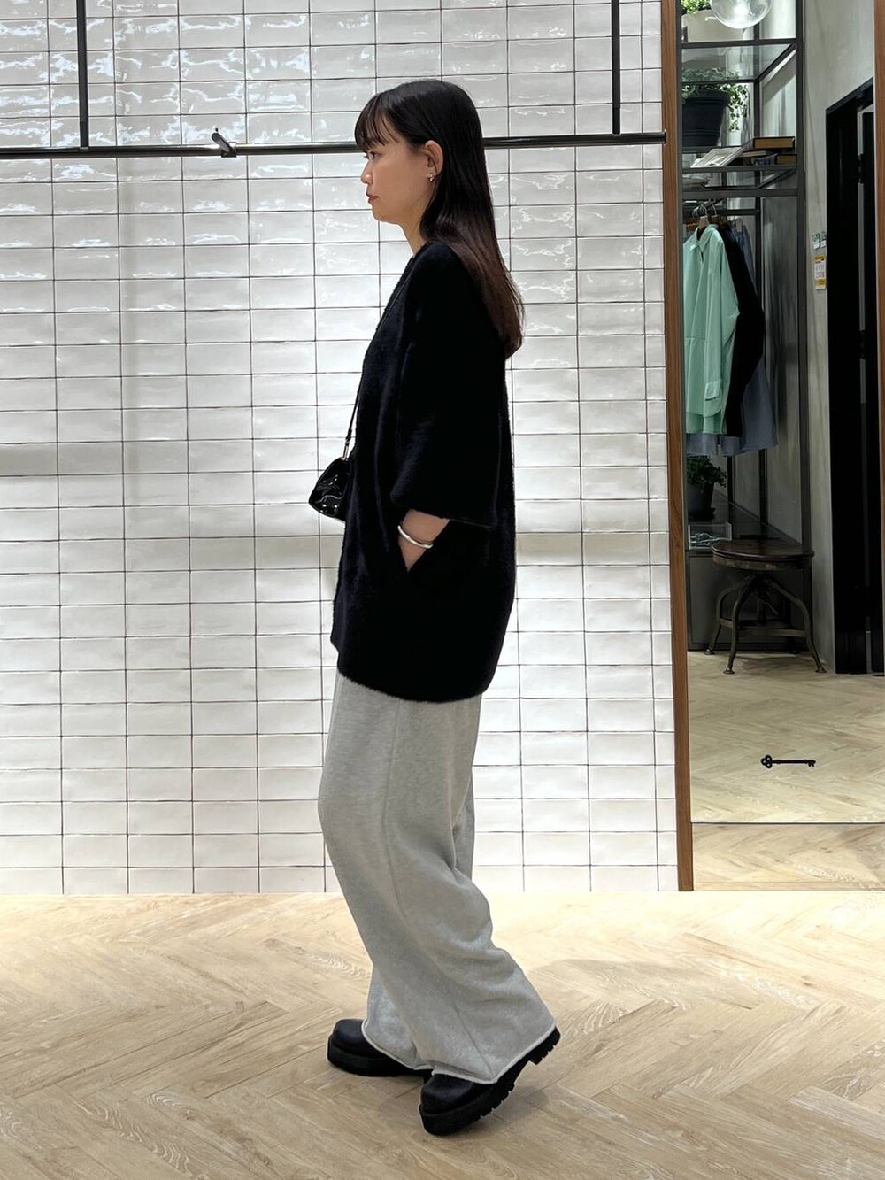 ブラック系のブーツ、ブラック系のカーディガン/ボレロ、グレー系のスウェットパンツを着用したレディースの秋コーディネートの2枚目の写真