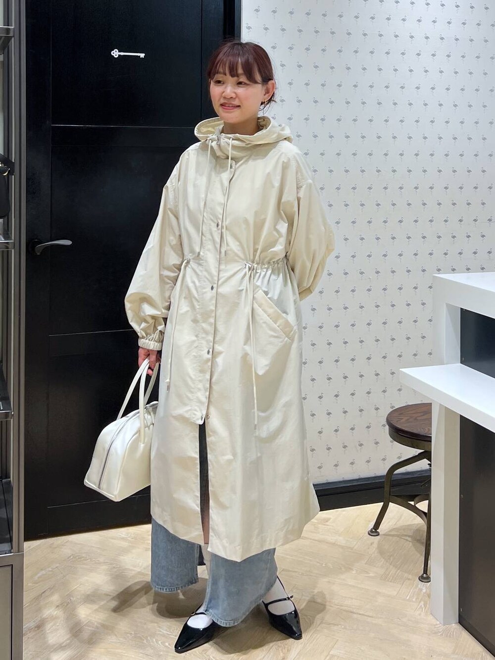 ブルー系のデニムスカート、ホワイト系のボストンバッグ、ブラック系のパンプスを着用したレディースの春コーディネートの5枚目の写真