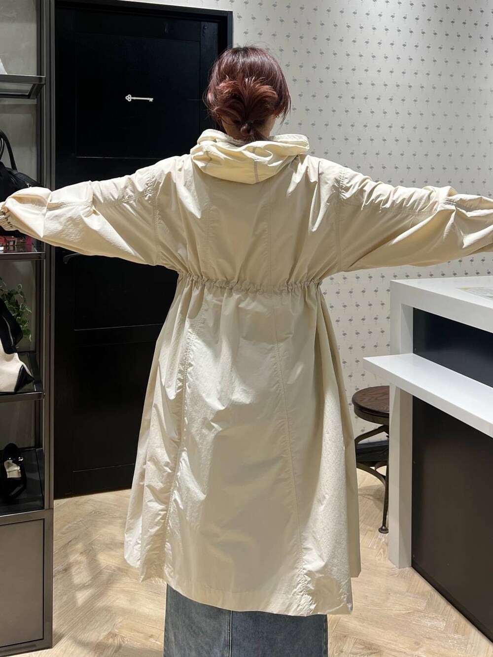 ブルー系のデニムスカート、ホワイト系のボストンバッグ、ブラック系のパンプスを着用したレディースの春コーディネートの6枚目の写真