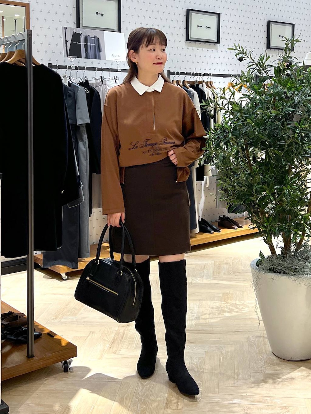 ブラウン系のスカート、ブラック系のブーツ、イエロー系のTシャツ/カットソーを着用したレディースの秋コーディネートの2枚目の写真