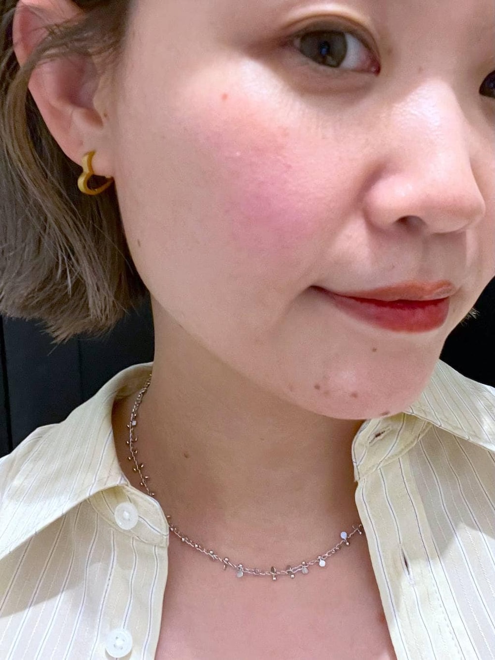 ベージュ系のスカート、ホワイト系のスニーカー、ホワイト系のショルダーバッグを着用したレディースの冬コーディネートの9枚目の写真