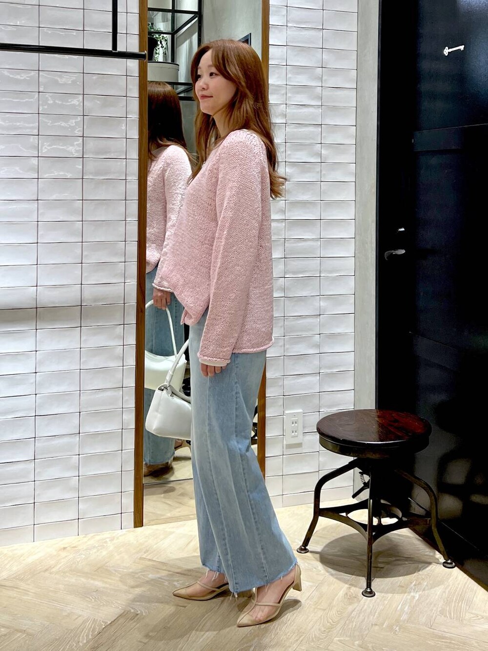 ブルー系のデニムパンツ、ホワイト系のTシャツ/カットソー、ピンク系のニット/セーターを着用したレディースの冬コーディネートの4枚目の写真