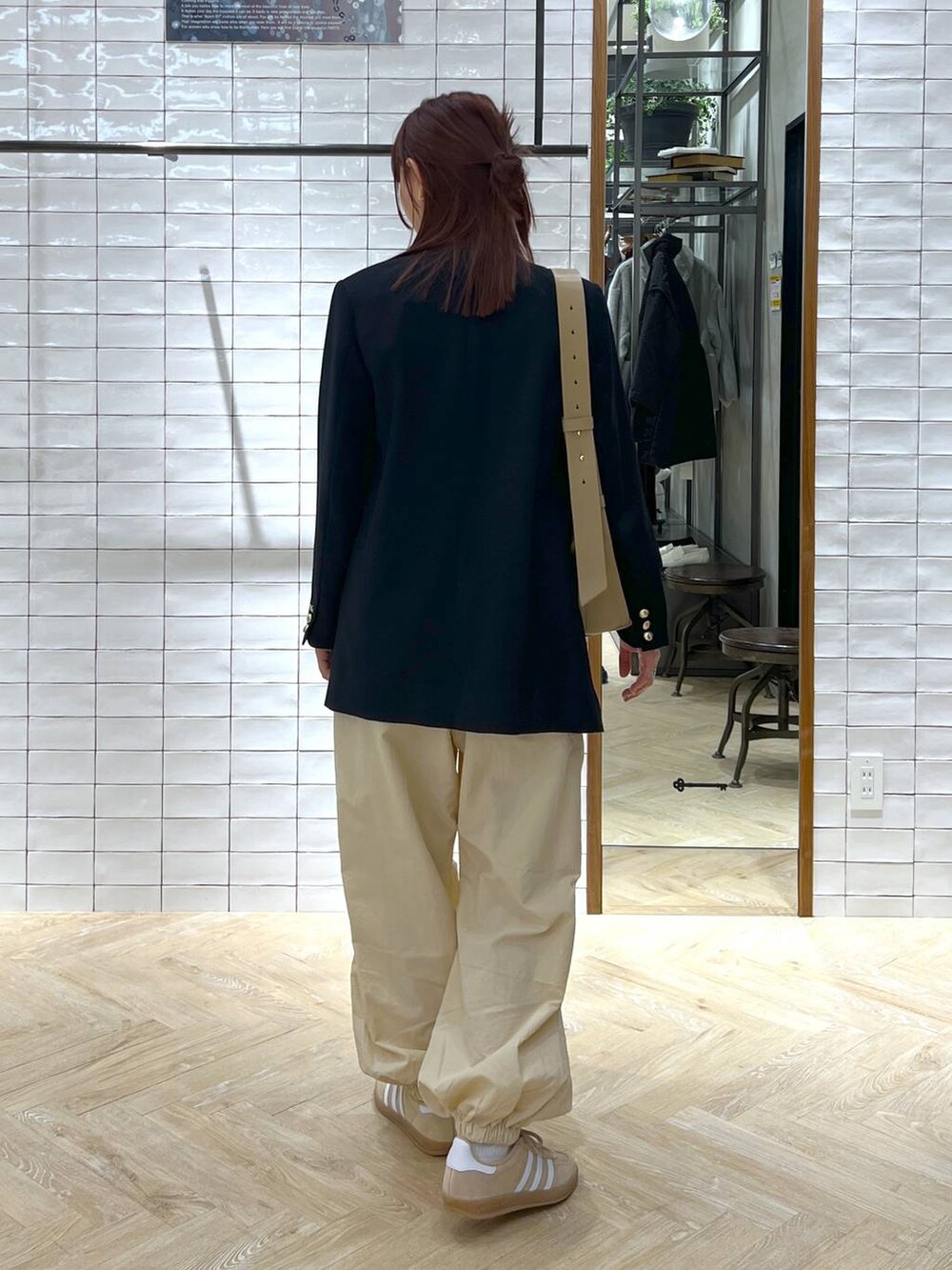 ブラウン系のショルダーバッグ、ブルー系のテーラードジャケット、ベージュ系のその他パンツを着用したレディースの冬コーディネートの3枚目の写真