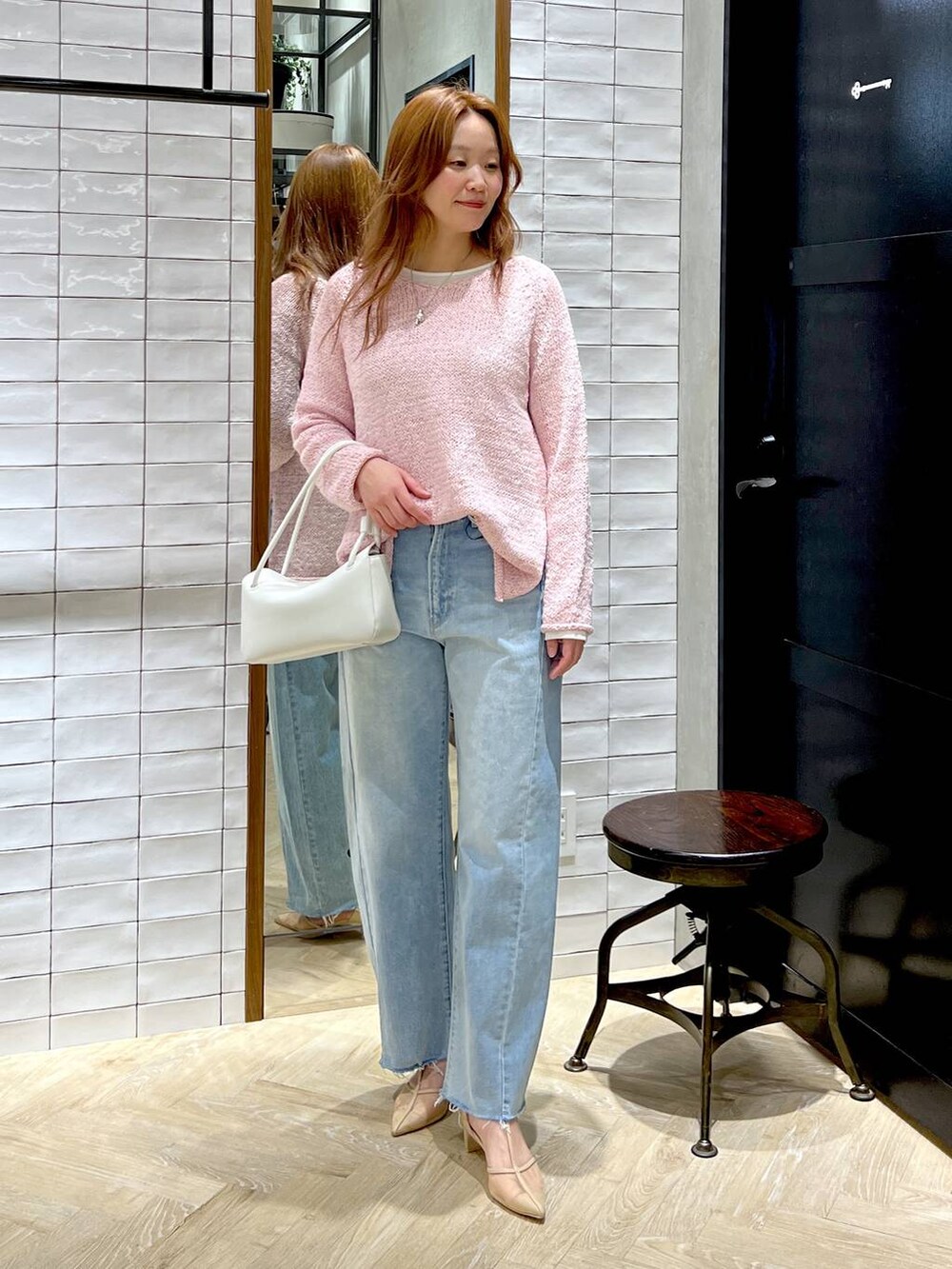 ブルー系のデニムパンツ、ホワイト系のTシャツ/カットソー、ピンク系のニット/セーターを着用したレディースの冬コーディネートの2枚目の写真