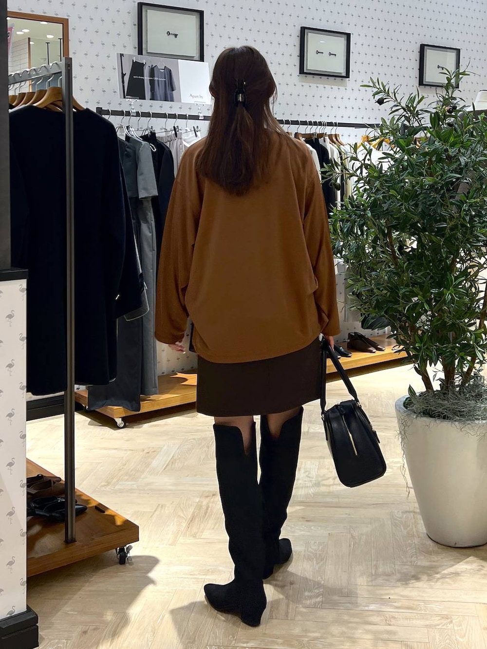 ブラウン系のスカート、ブラック系のブーツ、イエロー系のTシャツ/カットソーを着用したレディースの秋コーディネートの4枚目の写真