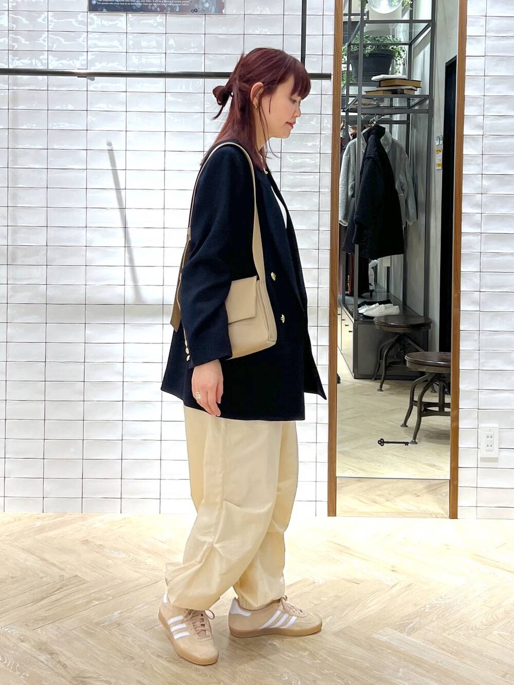 ブラウン系のショルダーバッグ、ブルー系のテーラードジャケット、ベージュ系のその他パンツを着用したレディースの冬コーディネートの2枚目の写真