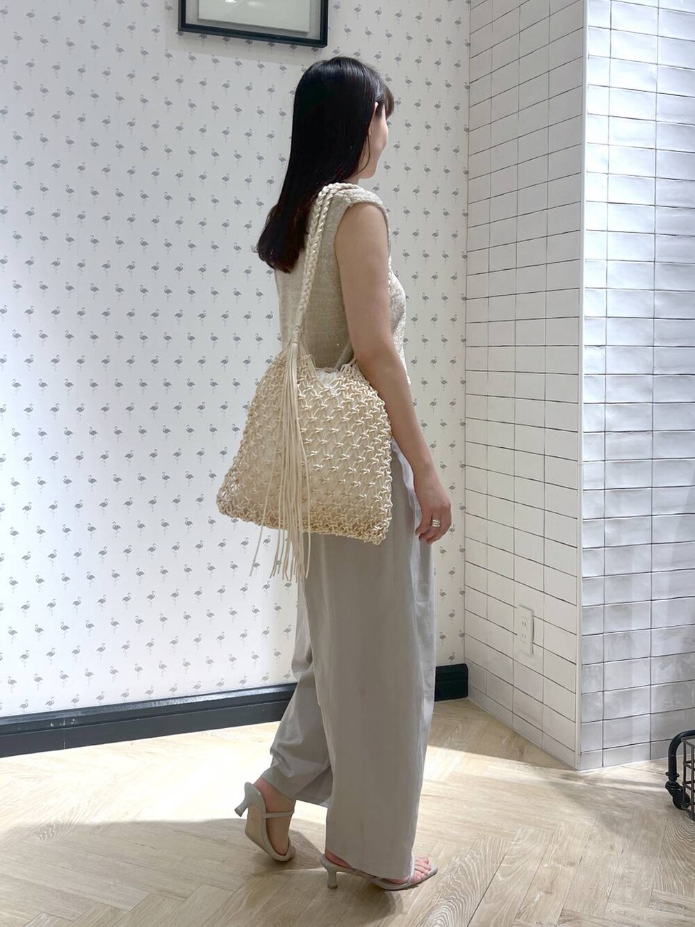 ホワイト系のショルダーバッグ、ホワイト系のサンダル、グレー系のその他パンツを着用したレディースの夏コーディネートの2枚目の写真