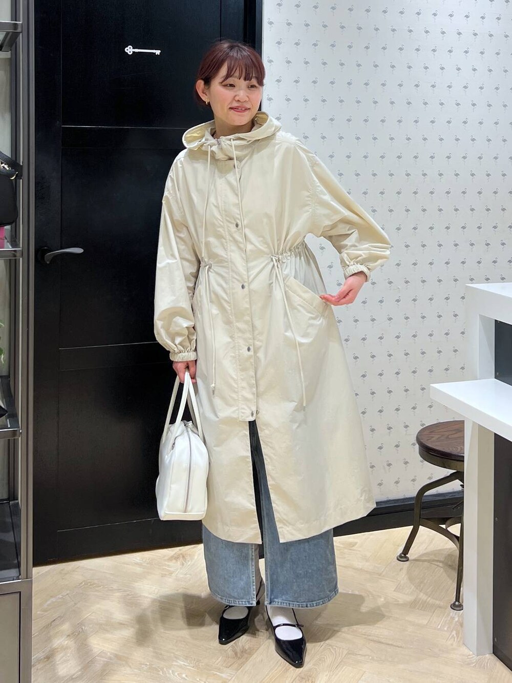 ブルー系のデニムスカート、ホワイト系のボストンバッグ、ブラック系のパンプスを着用したレディースの春コーディネートの3枚目の写真