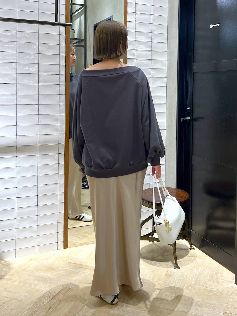 ベージュ系のスカート、ホワイト系のスニーカー、ホワイト系のショルダーバッグを着用したレディースの冬コーディネートの8枚目の写真