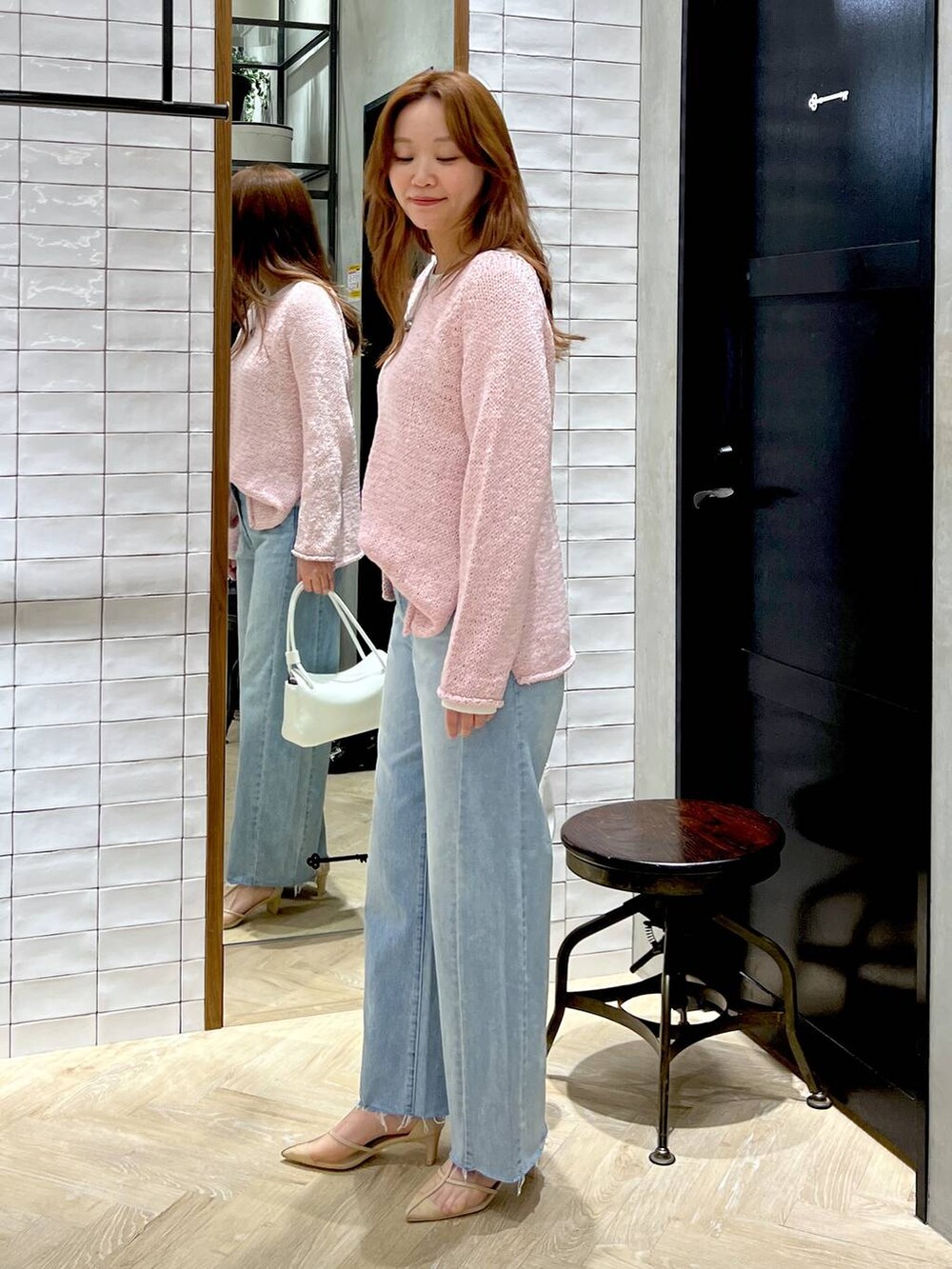 ブルー系のデニムパンツ、ホワイト系のTシャツ/カットソー、ピンク系のニット/セーターを着用したレディースの冬コーディネートの3枚目の写真