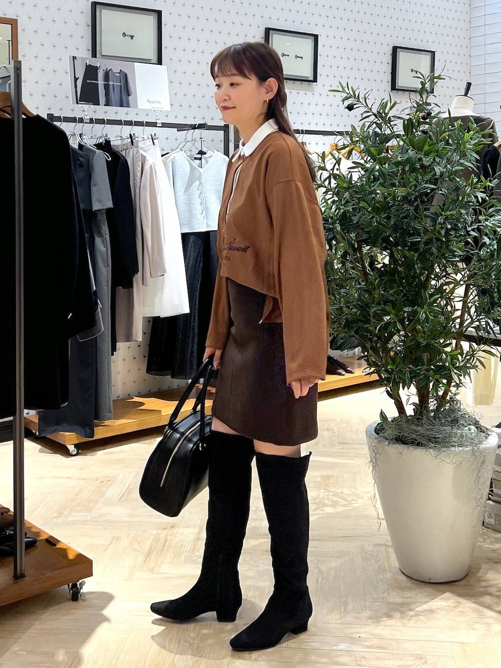 ブラウン系のスカート、ブラック系のブーツ、イエロー系のTシャツ/カットソーを着用したレディースの秋コーディネートの3枚目の写真