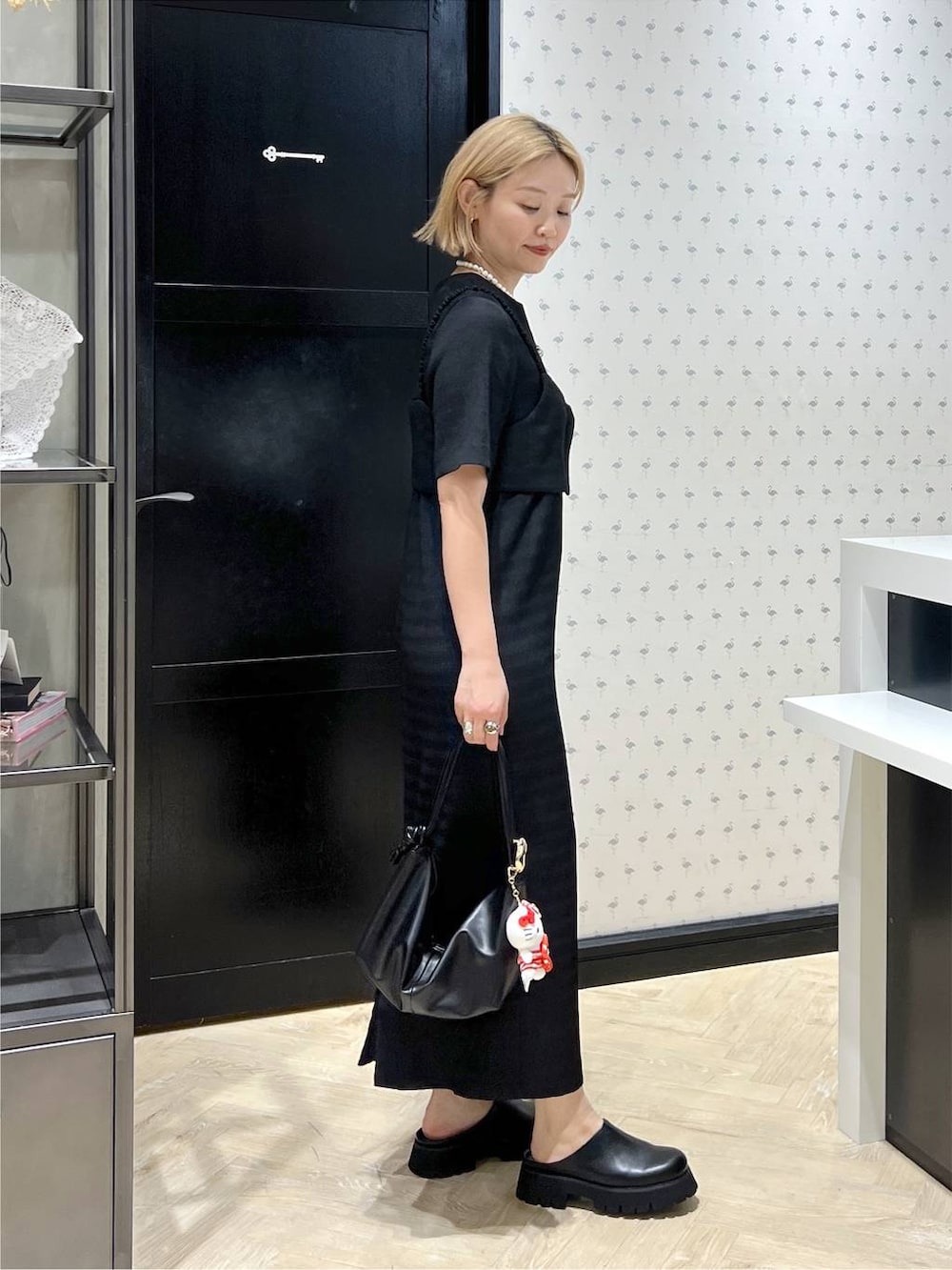 ブラック系のワンピース、ブラック系のショルダーバッグ、ブラック系のスリッポンを着用したレディースの夏コーディネートの3枚目の写真
