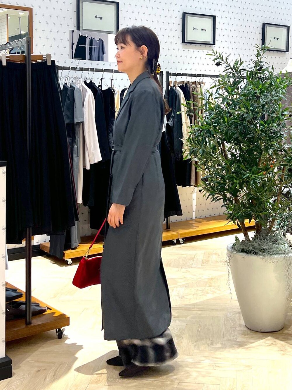 ブラウン系のパンプス、レッド系のショルダーバッグ、ブラック系のその他パンツを着用したレディースの秋コーディネートの3枚目の写真