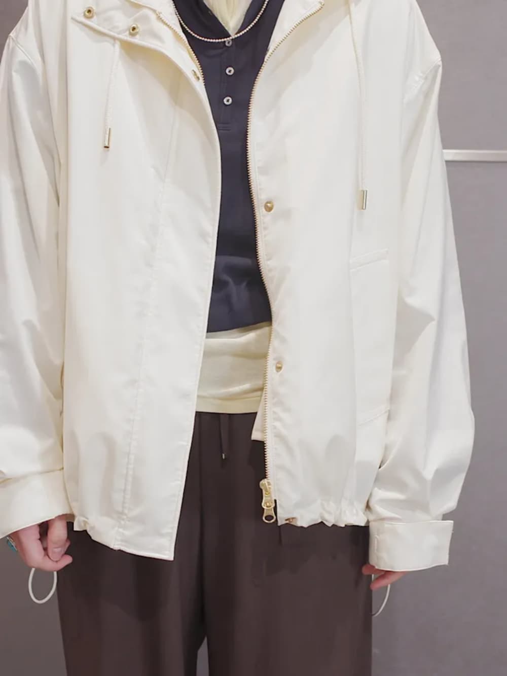 イエロー系のTシャツ/カットソー、ブルー系のTシャツ/カットソー、ホワイト系のマウンテンパーカーを着用したレディースの冬コーディネートの2枚目の写真
