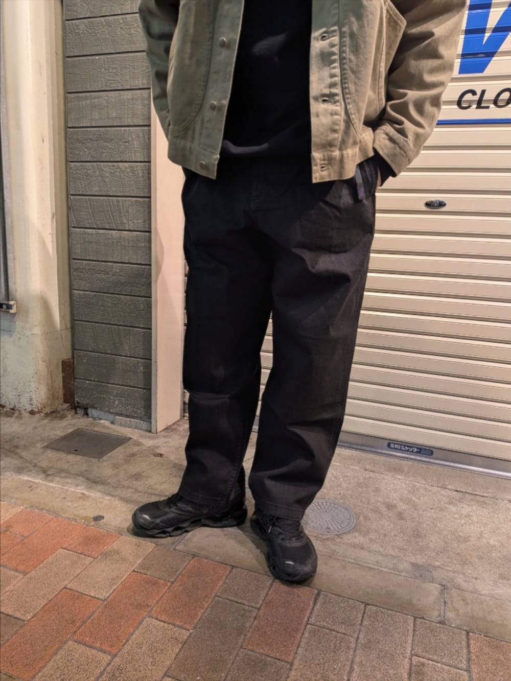 イエロー系のブルゾン、ブラック系のデニムパンツを着用したメンズの冬コーディネートの3枚目の写真