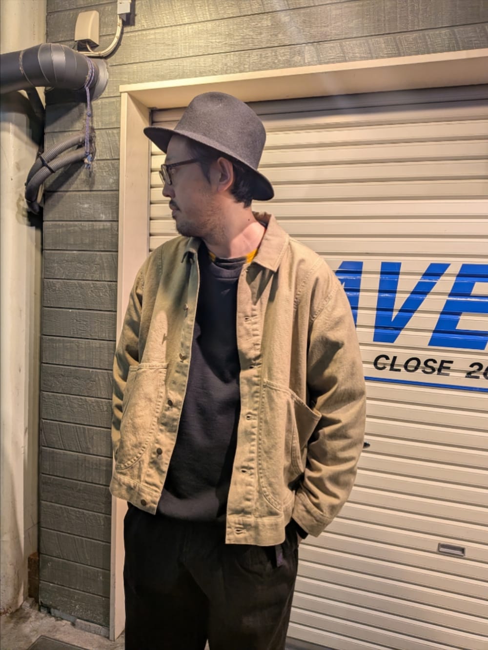 イエロー系のブルゾン、ブラック系のデニムパンツを着用したメンズの冬コーディネートの2枚目の写真