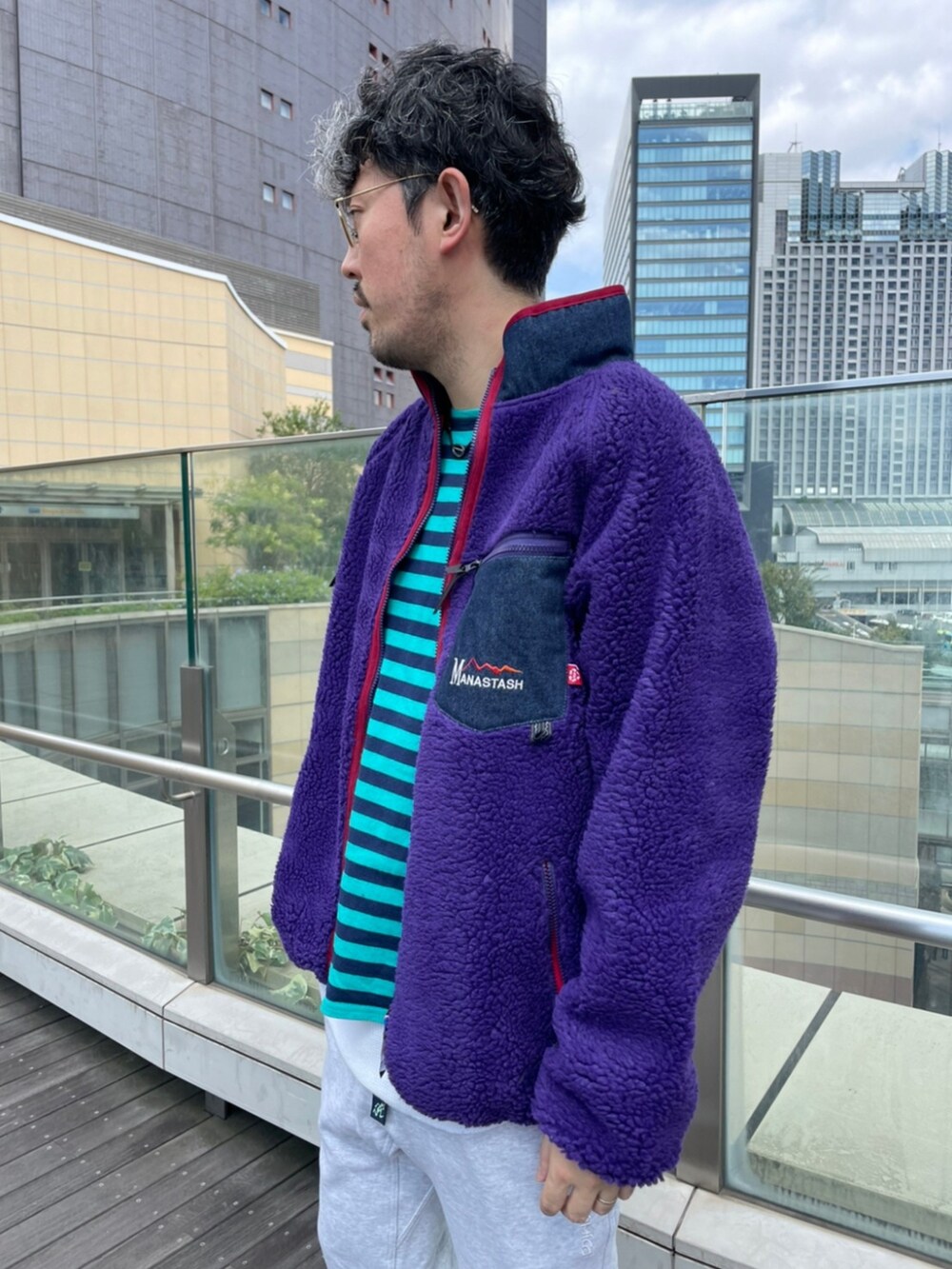 ブラウン系のスウェットパンツ、ブルー系のTシャツ/カットソー、パープル系のブルゾンを着用したメンズの秋コーディネートの2枚目の写真