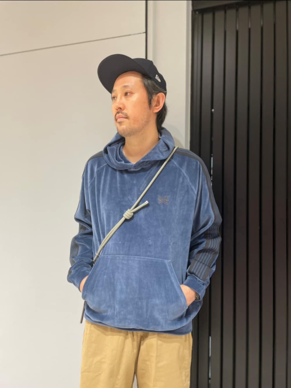 ベージュ系のその他パンツ、ブラック系のスニーカー、グリーン系のスマホグッズを着用したメンズの夏コーディネートの2枚目の写真