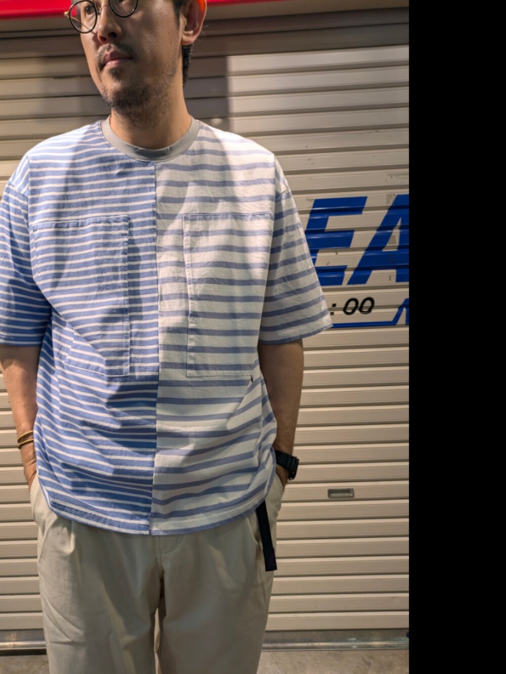 ブルー系のTシャツ/カットソー、ホワイト系のチノパンツを着用したメンズの夏コーディネートの3枚目の写真