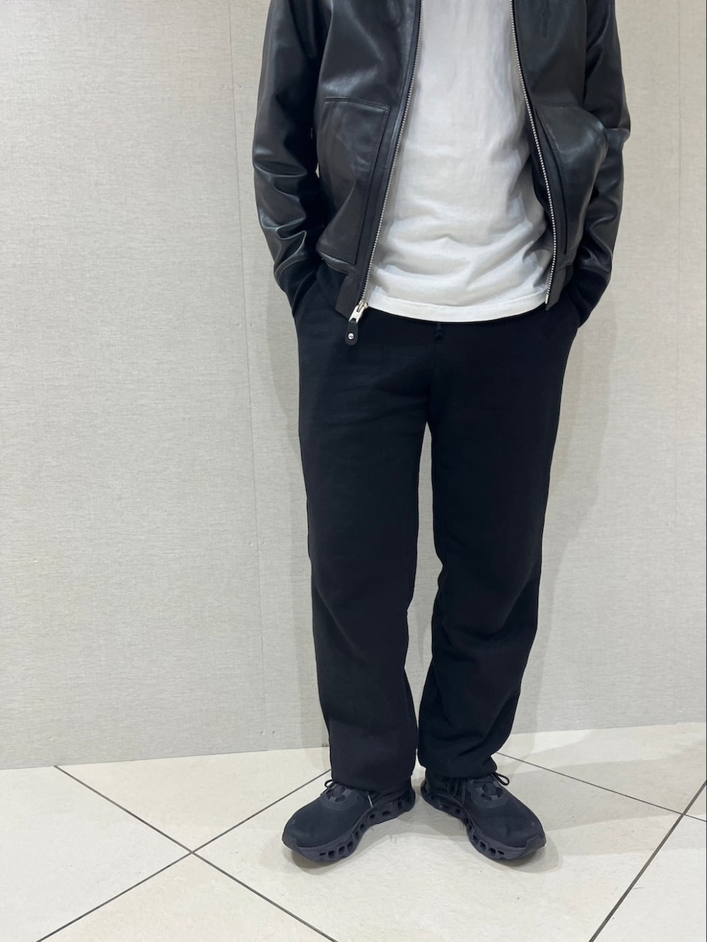 ブラック系のスウェットパンツ、ブラック系のスニーカー、ホワイト系のTシャツ/カットソーを着用したメンズの冬コーディネートの3枚目の写真