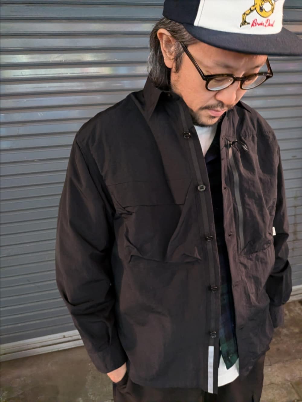 ブラック系のシャツ/ブラウス、ブラック系のカーゴパンツ、ブラック系のスニーカーを着用したメンズの冬コーディネートの2枚目の写真