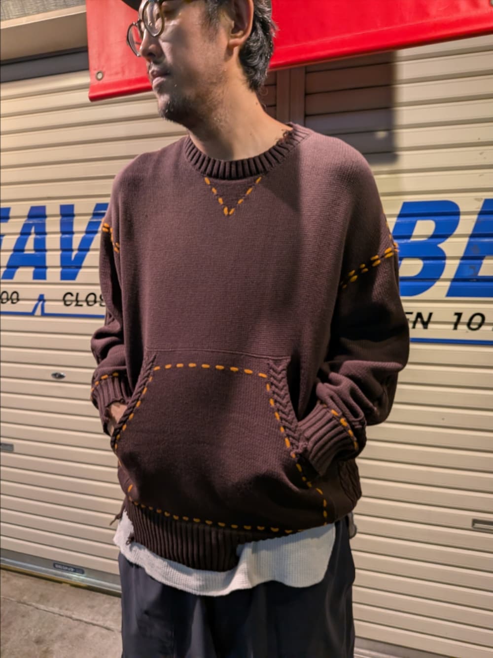 ブラウン系のニット/セーター、グレー系のその他パンツ、ブラック系のサンダルを着用したメンズの夏コーディネートの2枚目の写真