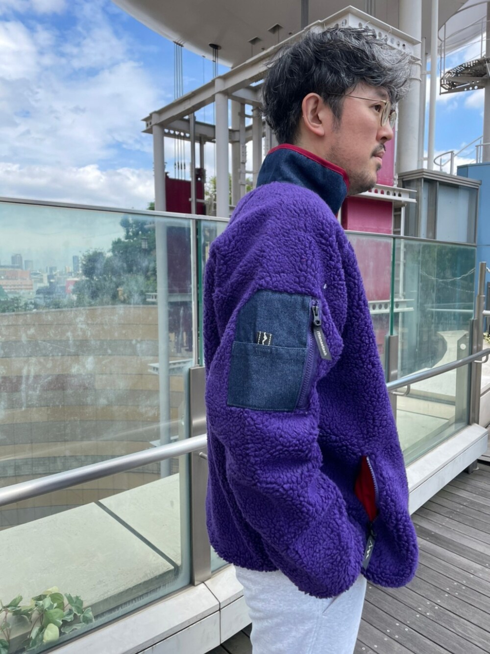 ブラウン系のスウェットパンツ、ブルー系のTシャツ/カットソー、パープル系のブルゾンを着用したメンズの秋コーディネートの3枚目の写真