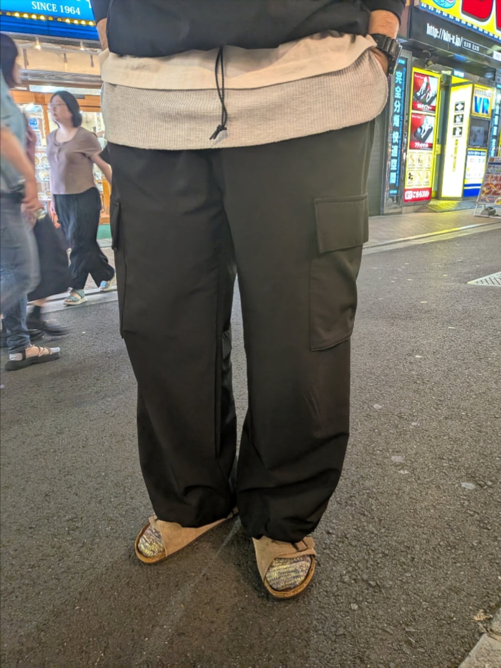 ブラック系のTシャツ/カットソー、ブラック系のカーゴパンツ、ベージュ系のサンダルを着用したメンズの秋コーディネートの3枚目の写真