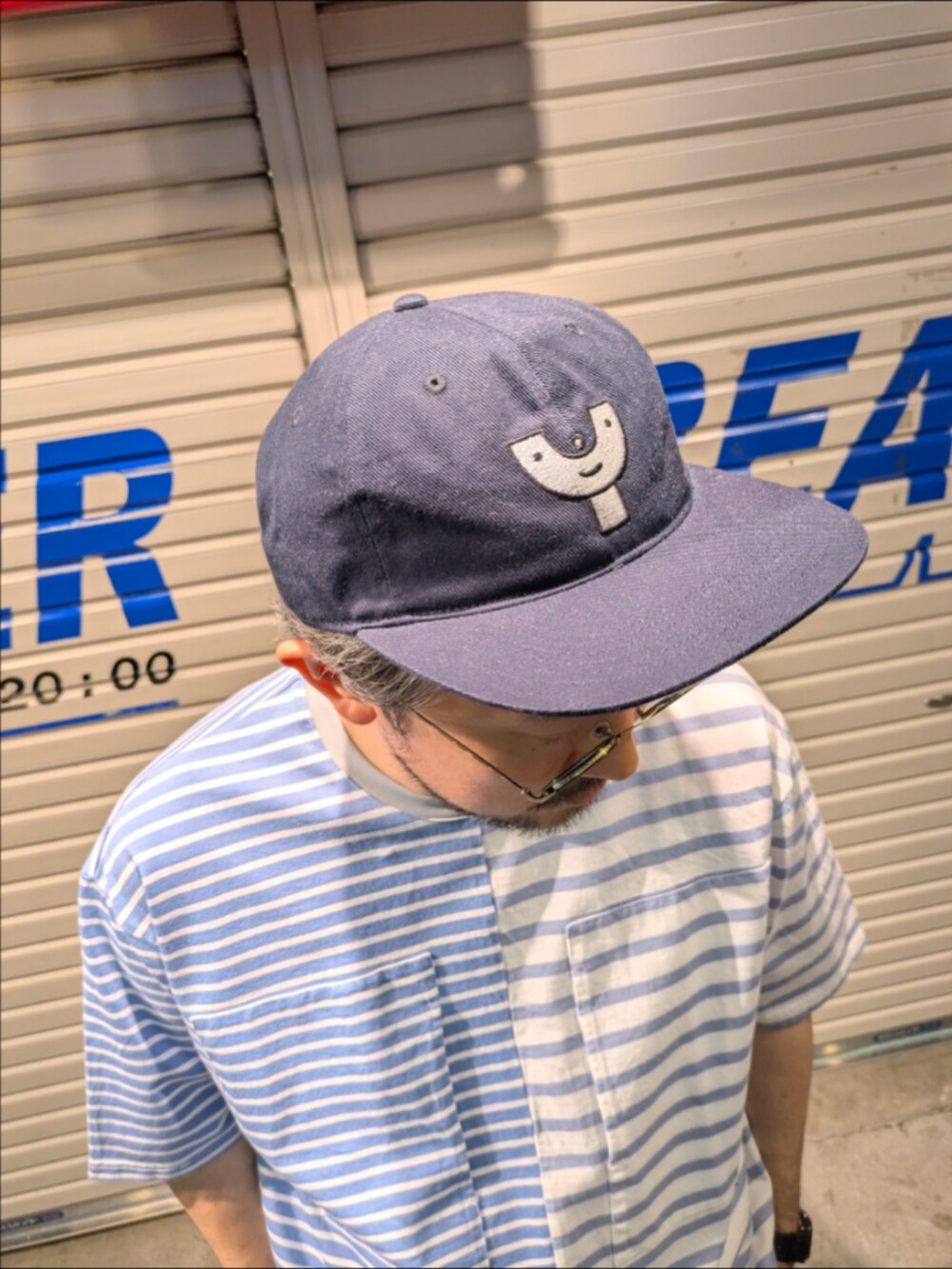 ブルー系のTシャツ/カットソー、ホワイト系のチノパンツを着用したメンズの夏コーディネートの4枚目の写真