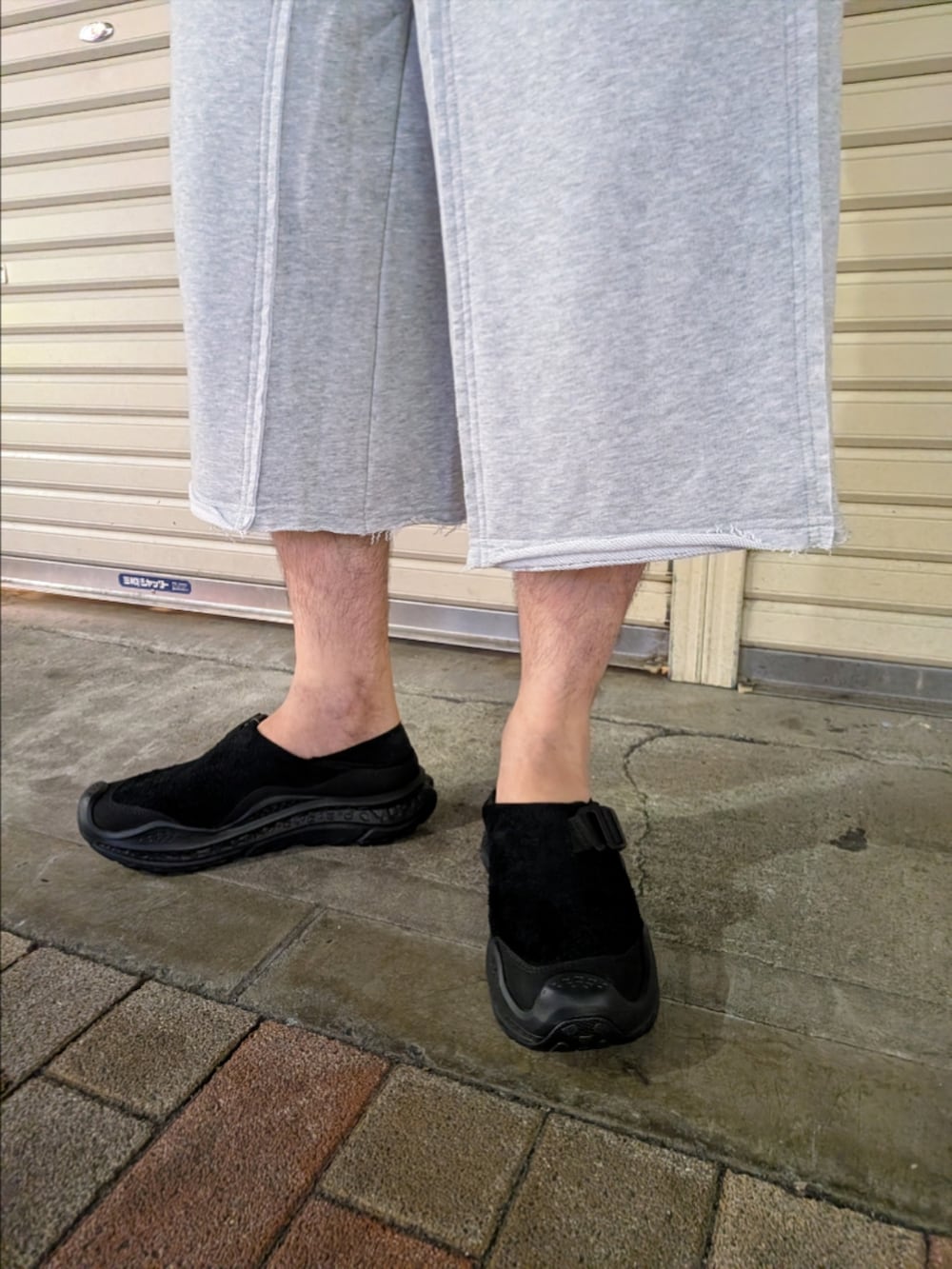 グレー系のその他パンツ、ブラック系のサンダル、ブルー系のニット/セーターを着用したメンズの夏コーディネートの4枚目の写真