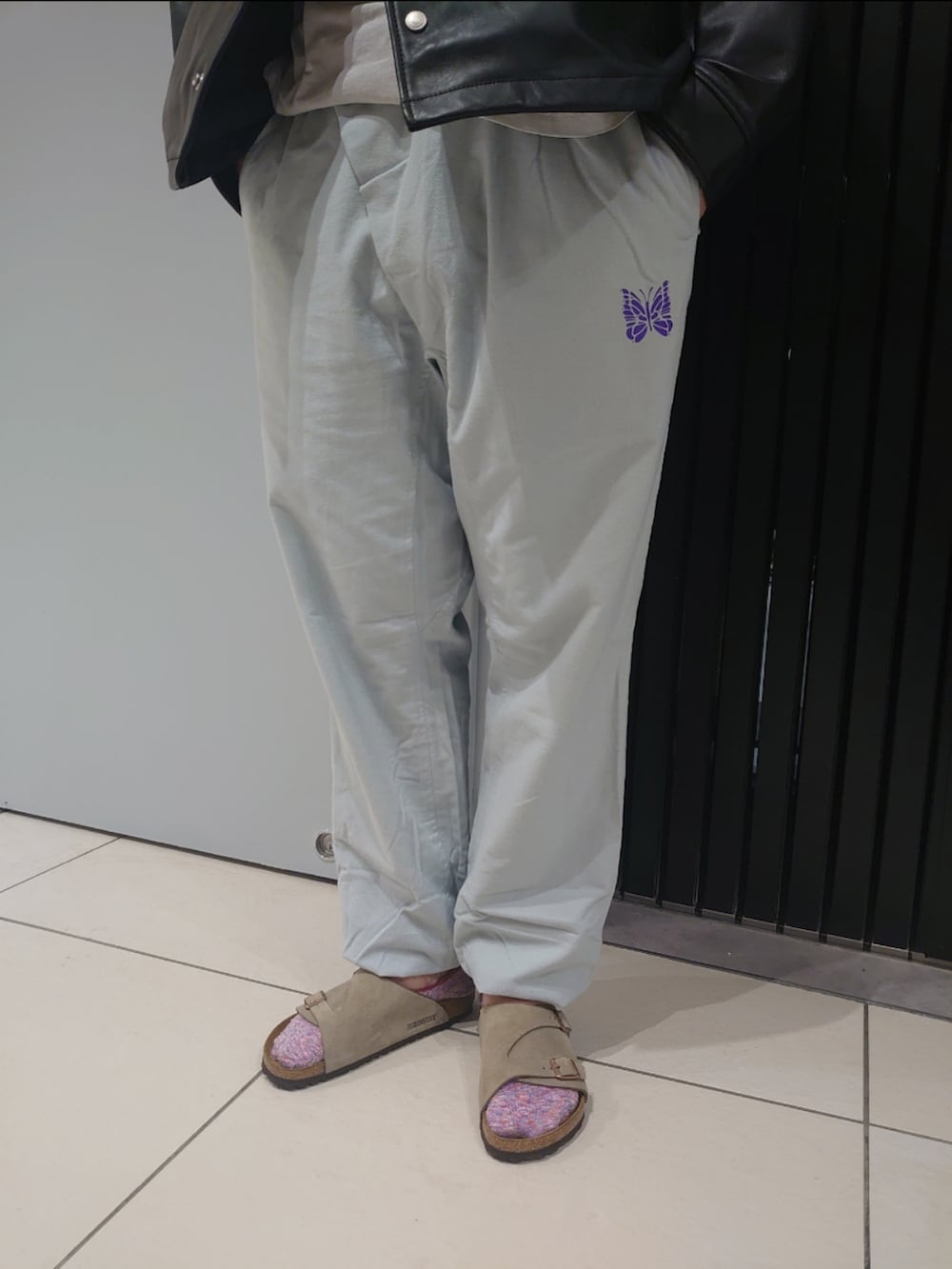 ベージュ系のサンダル、ブラック系のライダースジャケットを着用したメンズの夏コーディネートの3枚目の写真