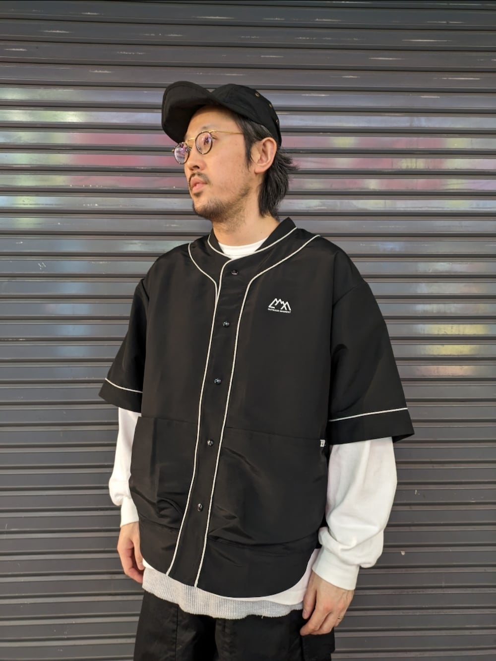 ブラック系のシャツ/ブラウス、ブラック系のキャップを着用したメンズの春コーディネートの2枚目の写真