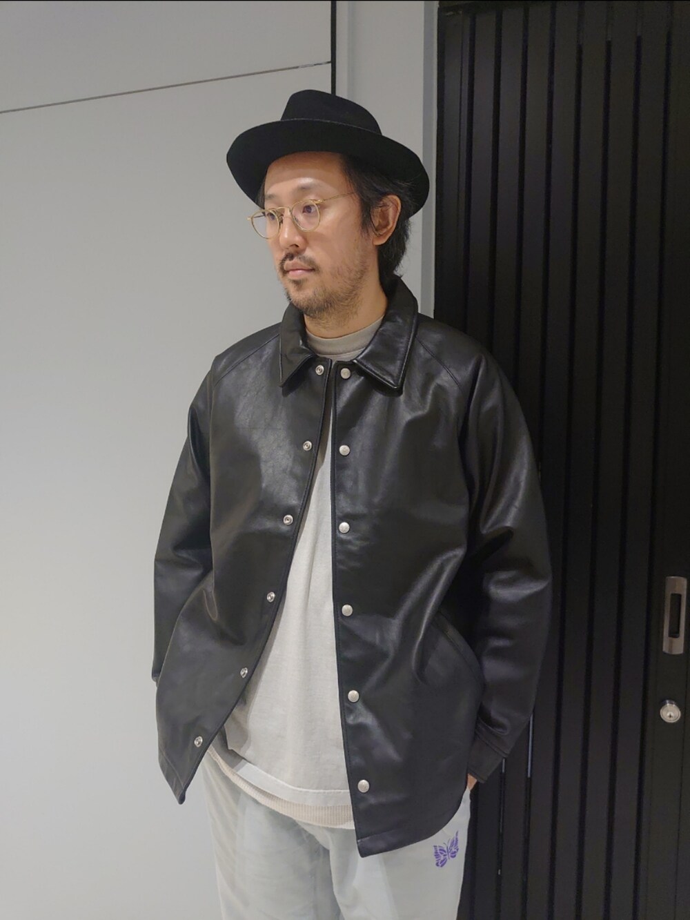 ベージュ系のサンダル、ブラック系のライダースジャケットを着用したメンズの夏コーディネートの2枚目の写真