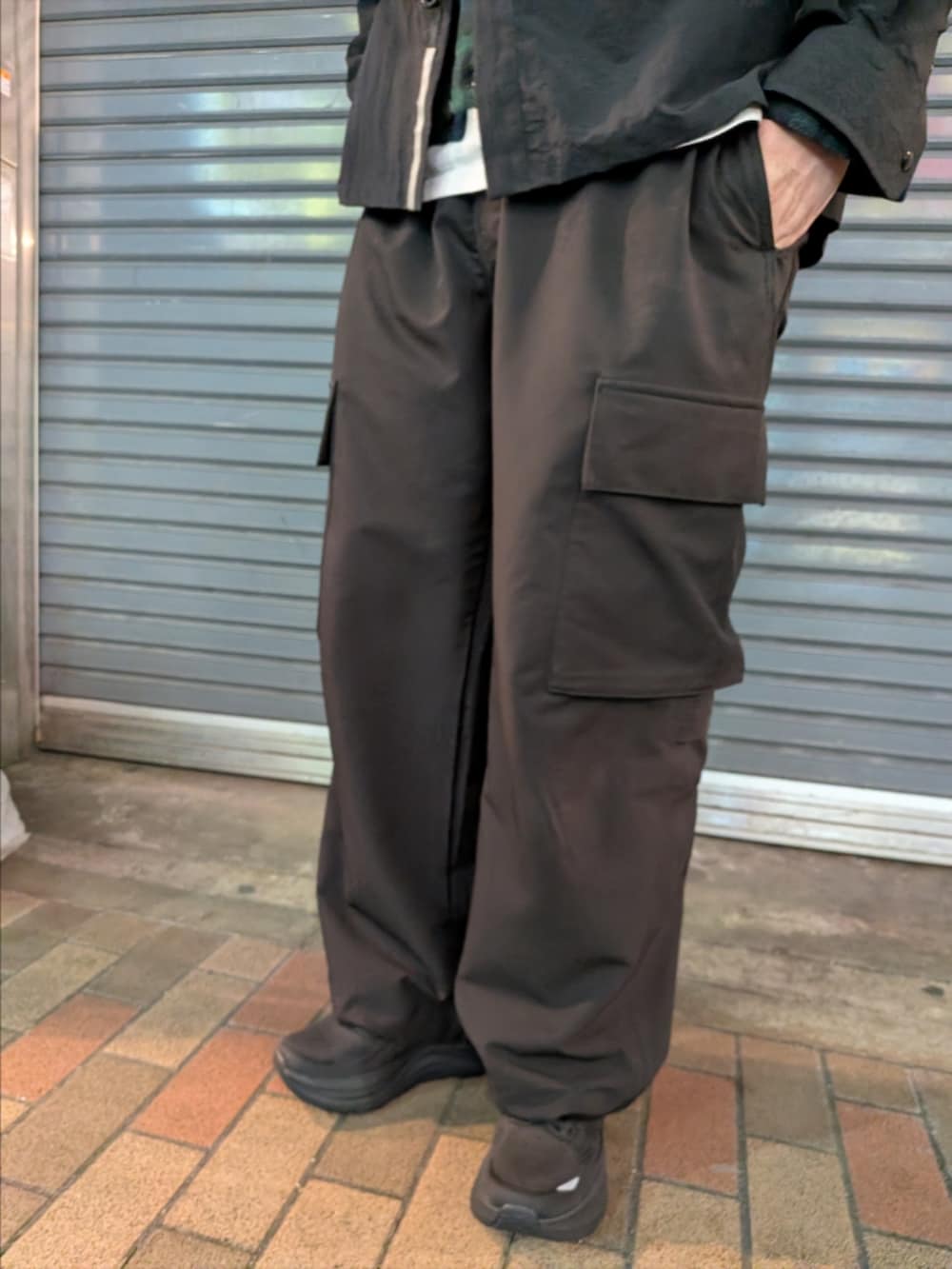 ブラック系のシャツ/ブラウス、ブラック系のカーゴパンツ、ブラック系のスニーカーを着用したメンズの冬コーディネートの3枚目の写真