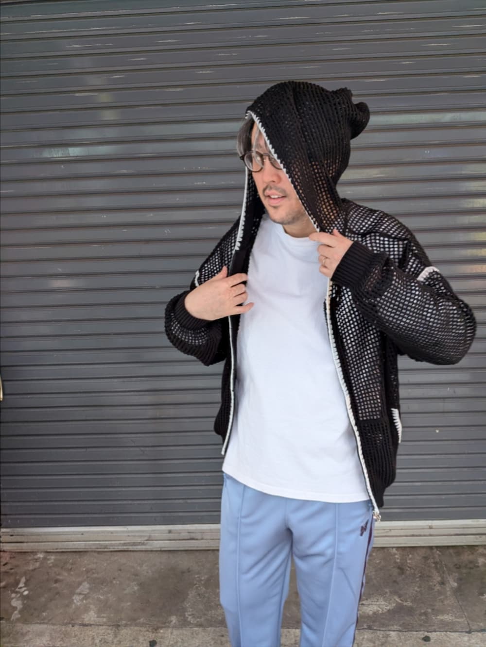 ブラック系のパーカー、ブラック系のブルゾンを着用したメンズの春コーディネートの3枚目の写真