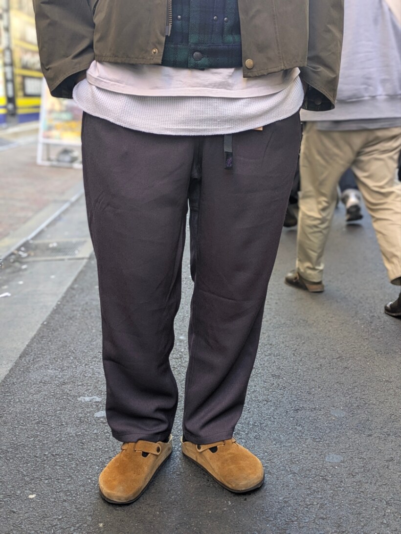 グリーン系のブルゾン、グレー系のスラックスを着用したメンズの冬コーディネートの3枚目の写真