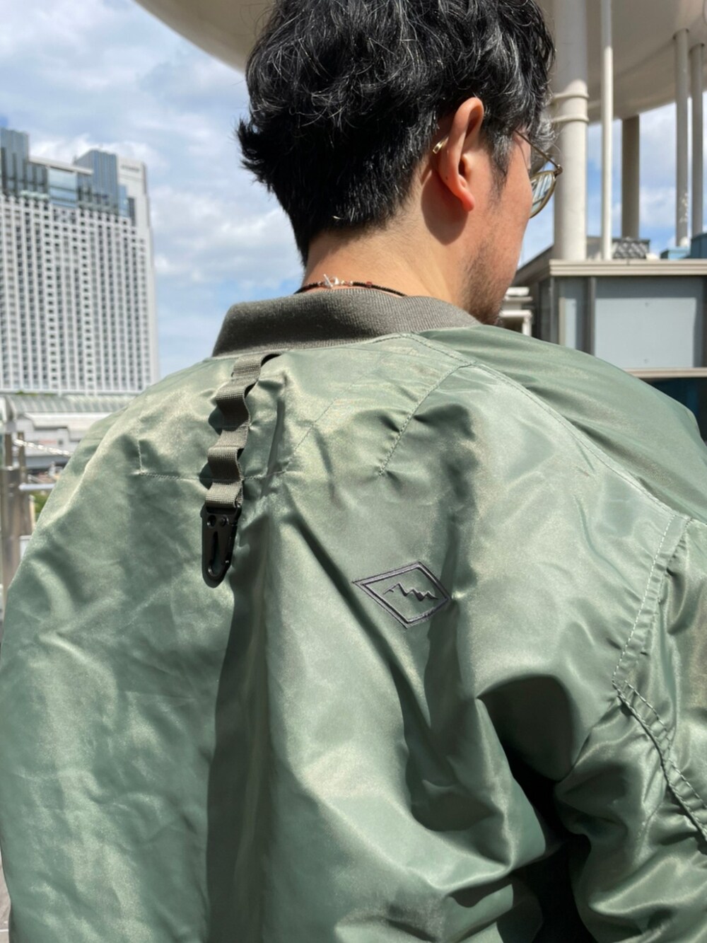 グリーン系のMA-1、ブラウン系のスウェットパンツ、グリーン系のTシャツ/カットソーを着用したメンズの秋コーディネートの3枚目の写真