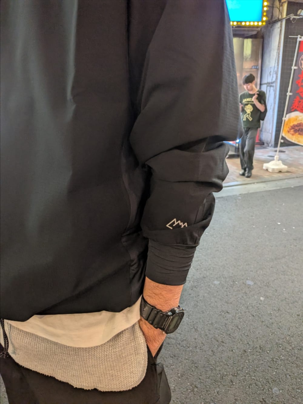 ブラック系のTシャツ/カットソー、ブラック系のカーゴパンツ、ベージュ系のサンダルを着用したメンズの秋コーディネートの2枚目の写真