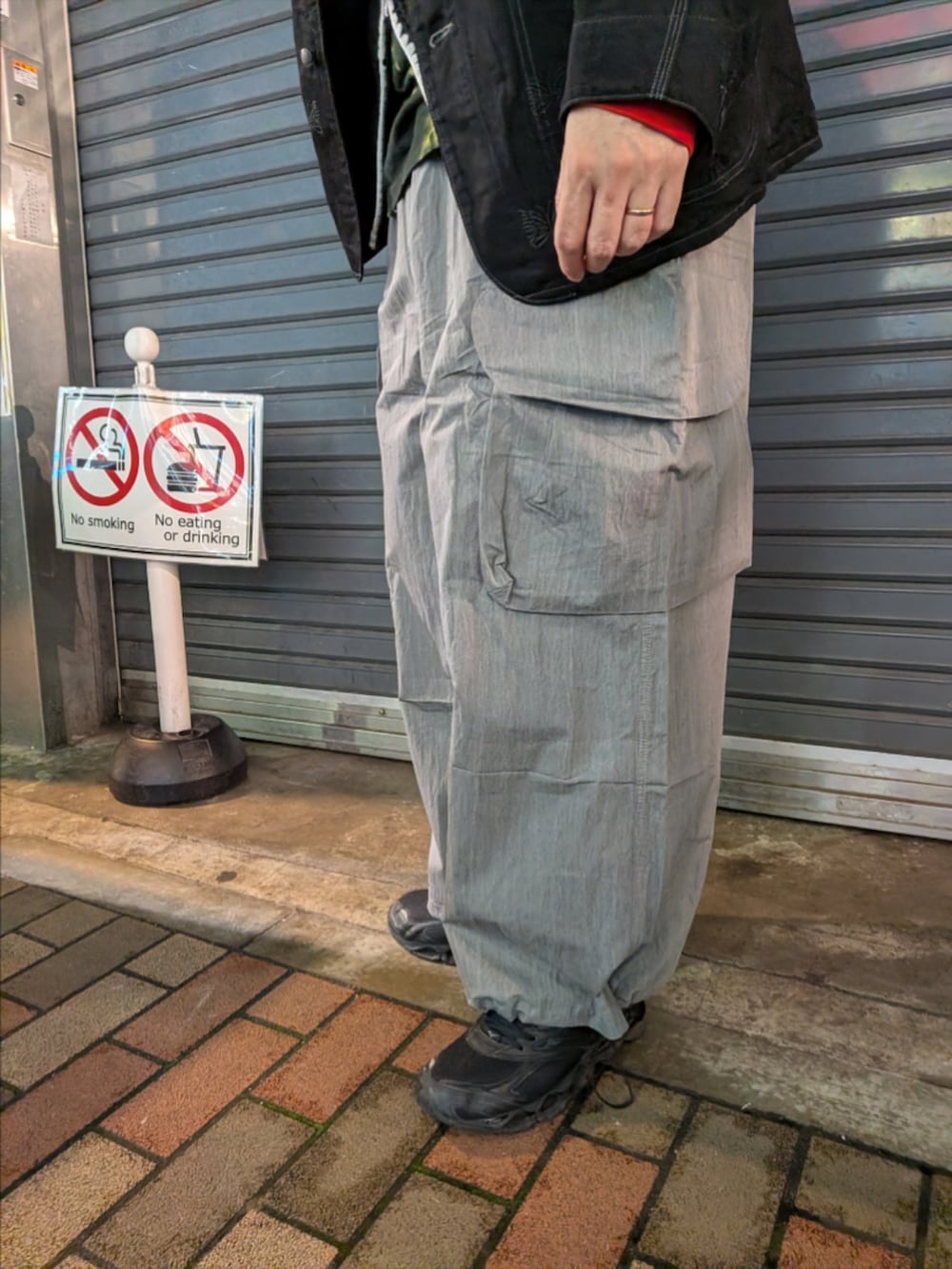 ブラック系のパーカー、グレー系のカーゴパンツを着用したメンズの春コーディネートの3枚目の写真