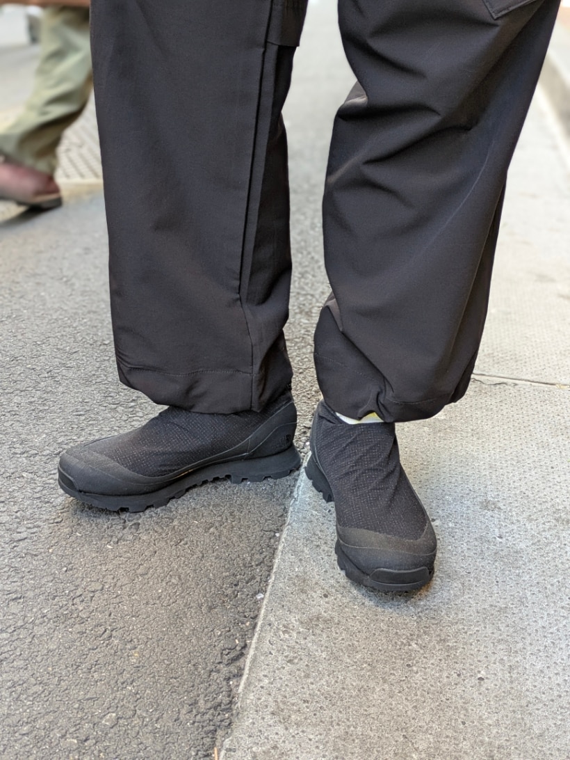 ブラック系のナイロンジャケット、ブラック系のスニーカー、ブラック系のカーゴパンツを着用したメンズの春コーディネートの3枚目の写真