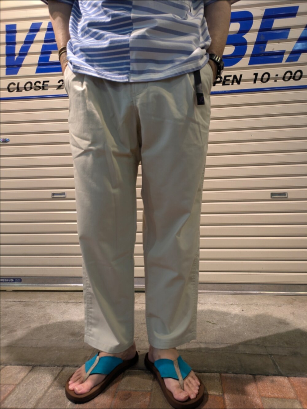 ブルー系のTシャツ/カットソー、ホワイト系のチノパンツを着用したメンズの夏コーディネートの2枚目の写真