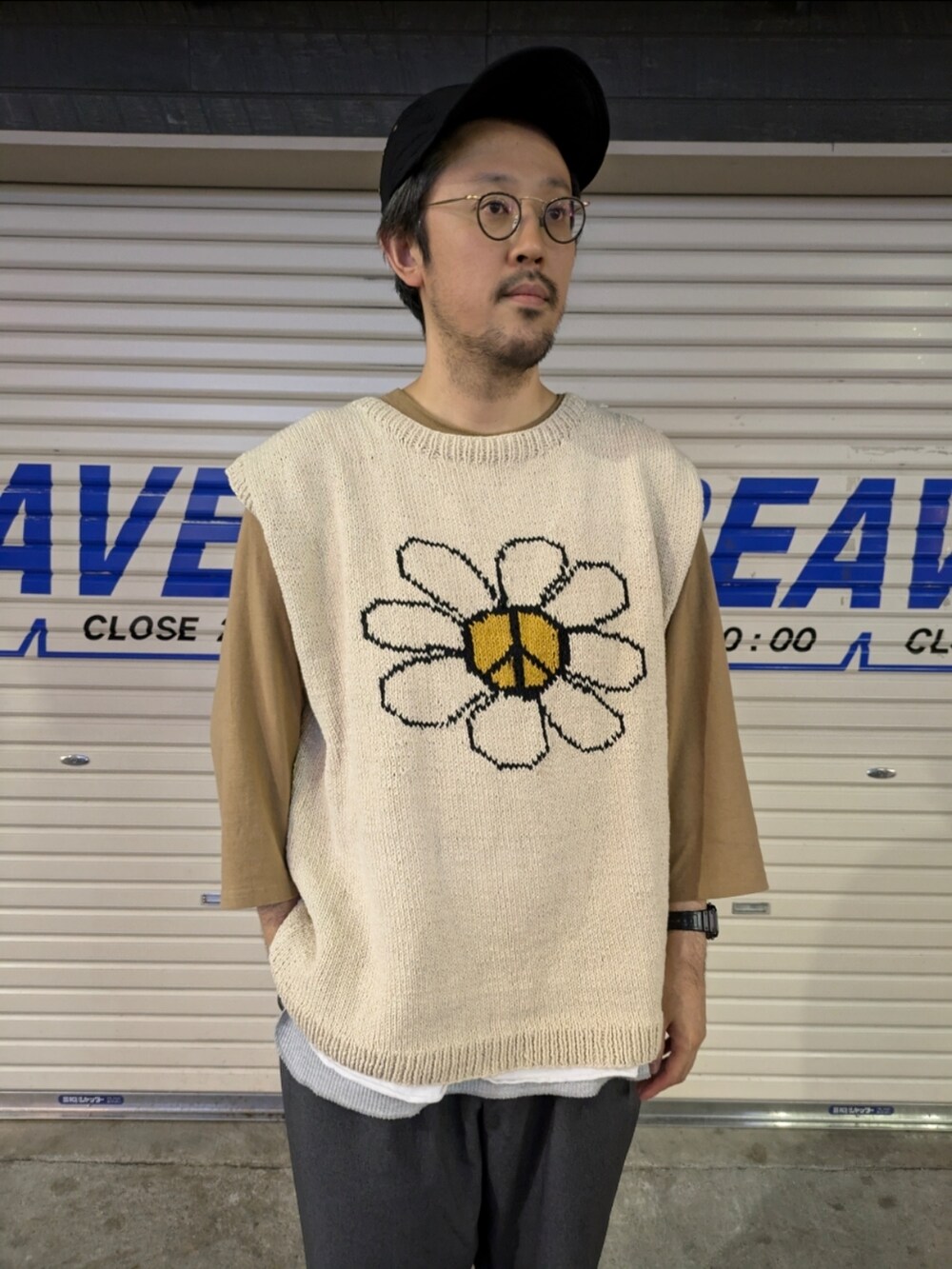 ブルー系のスラックス、ブラウン系のTシャツ/カットソー、ゴールド系のニット/セーターを着用したメンズの夏コーディネートの2枚目の写真