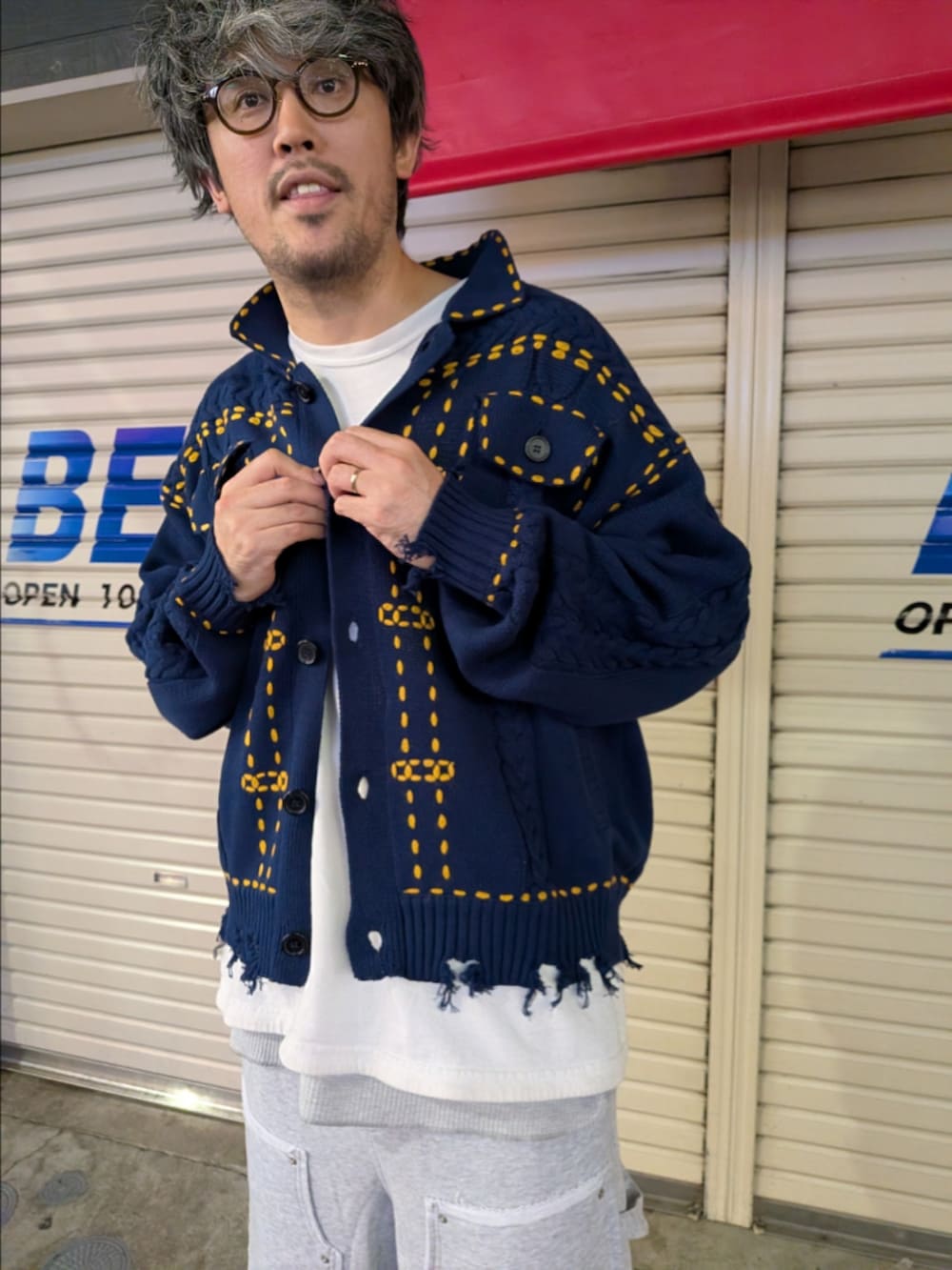 グレー系のその他パンツ、ブラック系のサンダル、ブルー系のニット/セーターを着用したメンズの夏コーディネートの2枚目の写真