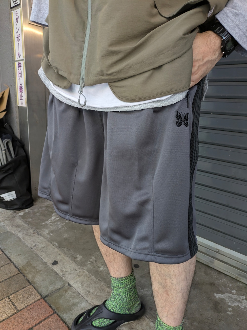 グレー系のベスト、ブラック系のサンダルを着用したメンズの夏コーディネートの3枚目の写真